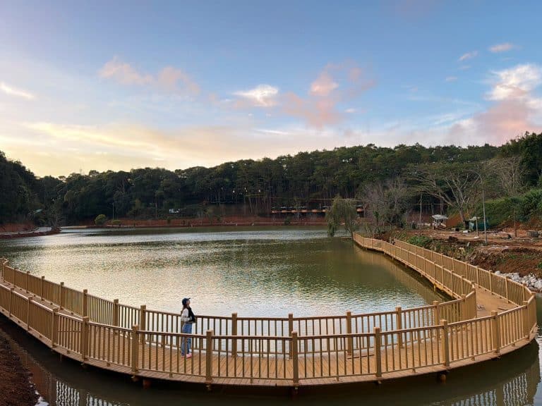 DANH SÁCH 20 ĐIỂM VUI CHƠI TẠI MĂNG ĐEN - REVIEW MĂNG ĐEN 4 Mặt nước Hồ Dakke Măng Đen phẳng lặng phản chiếu bầu trời xanh và rặng núi xanh thẫm bao quanh buổi sáng sớm