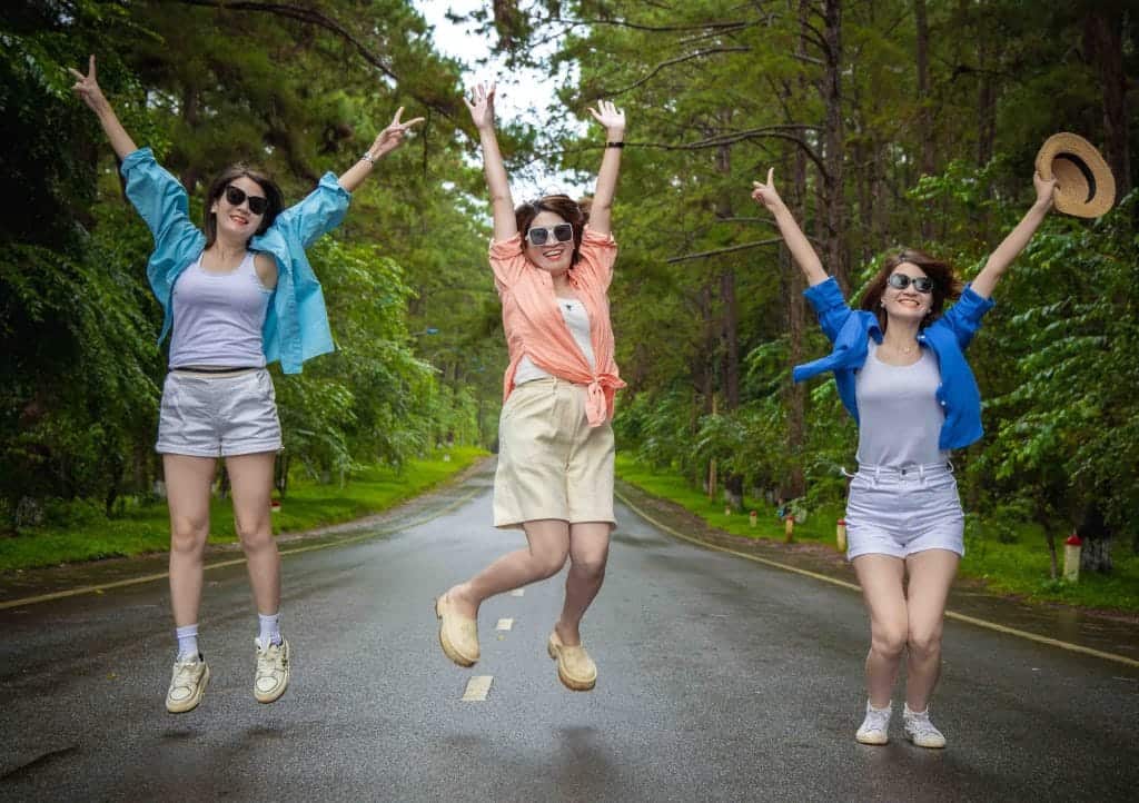 nhóm khách vui vẻ chụp ảnh giữa đường thông trong tour tham quan măng đen