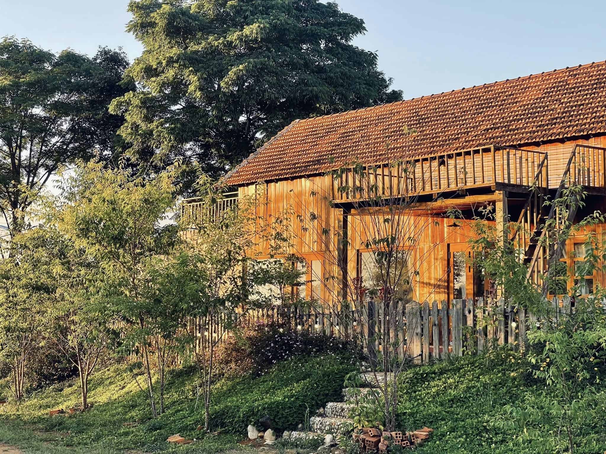 homestay Măng Đen góc nhìn từ ngoài vào homestay với nhiều cây, hoa ở Pinky Moon homestay