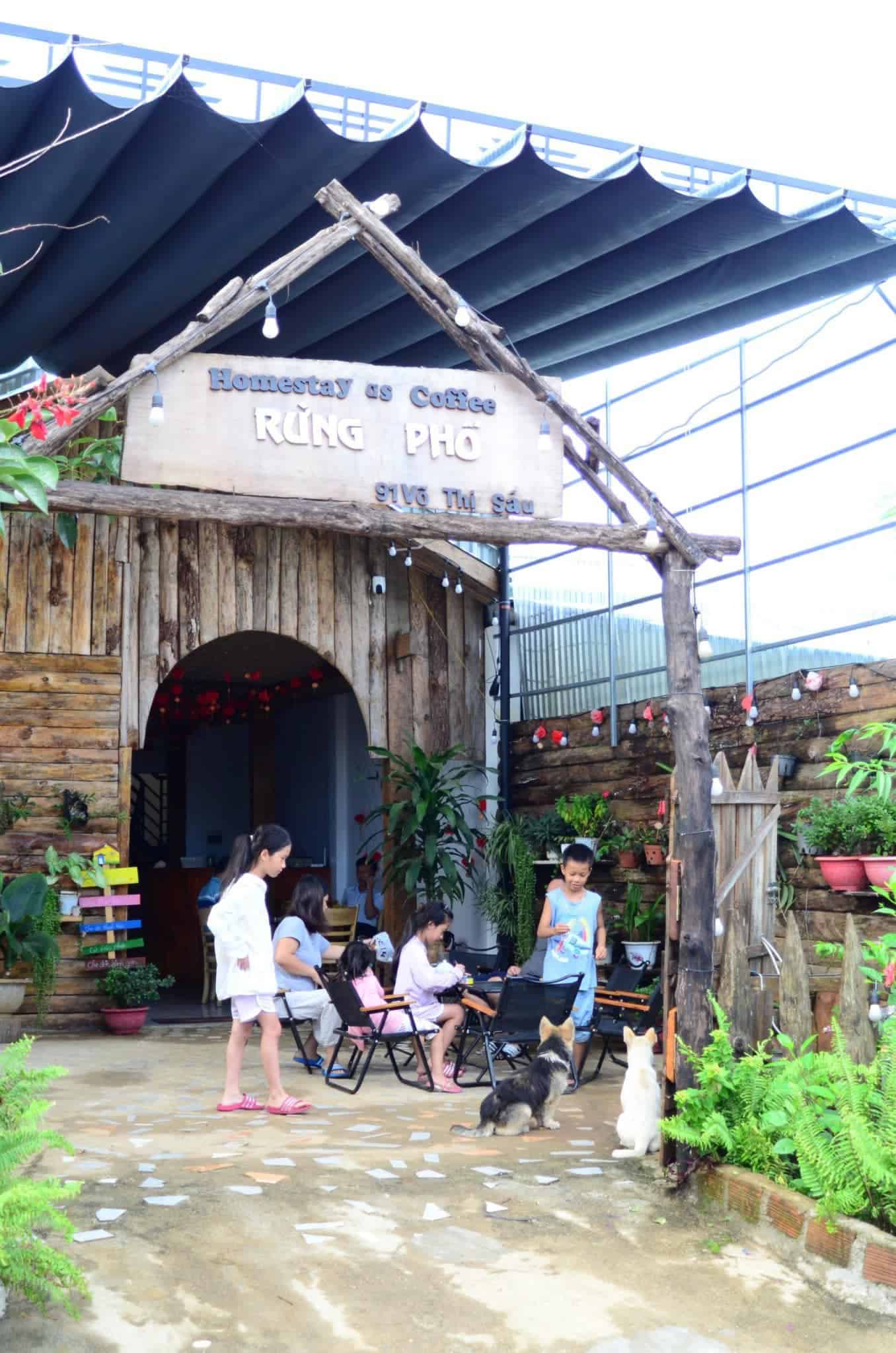 homestay Măng Đen đoàn khách ngồi chơi trước cổng Rừng Phố homestay