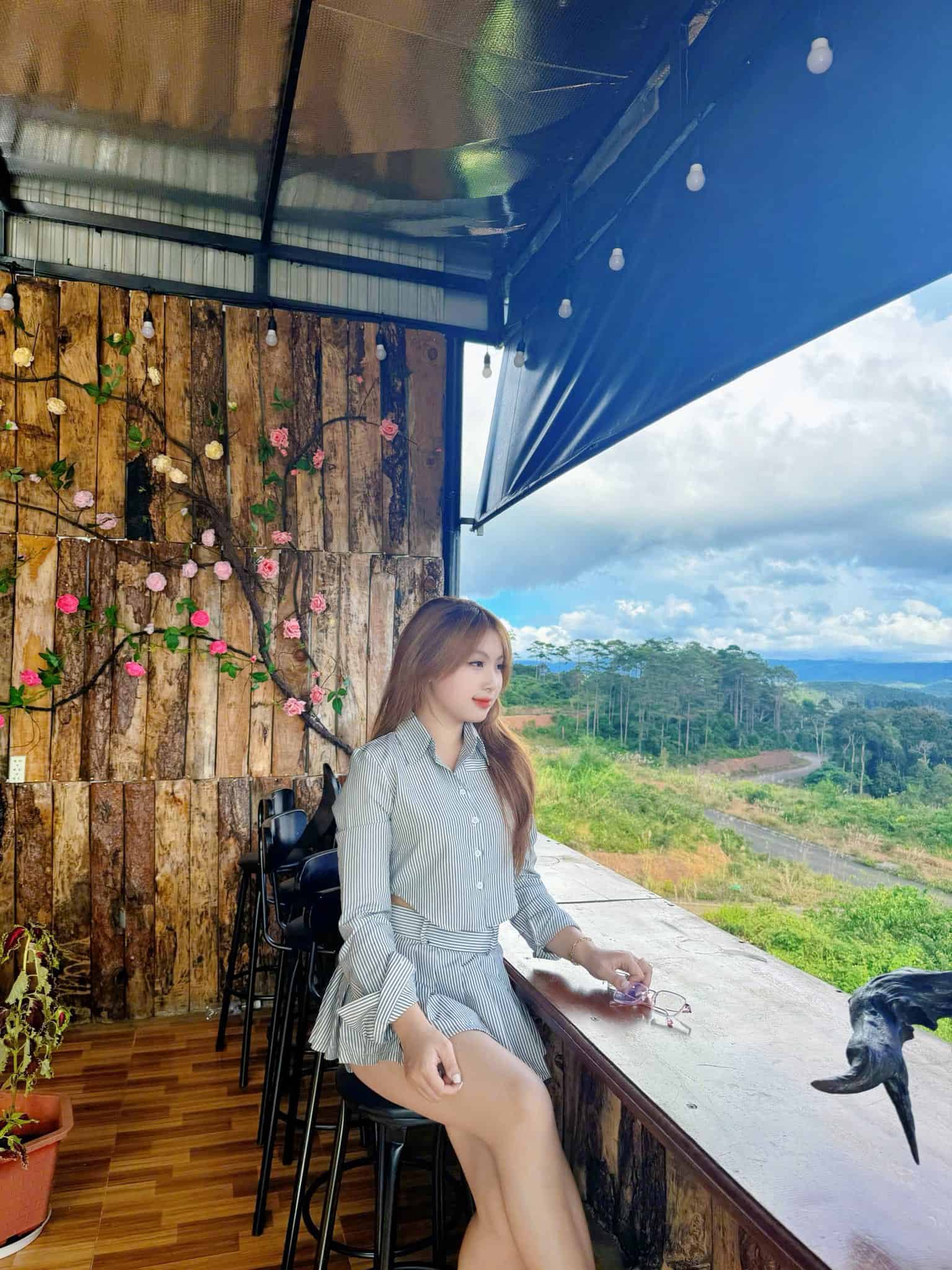 homestay Măng Đen cô gái ngồi chụp ảnh bên bàn ghế ngắm đường ở Rừng Phố homestay