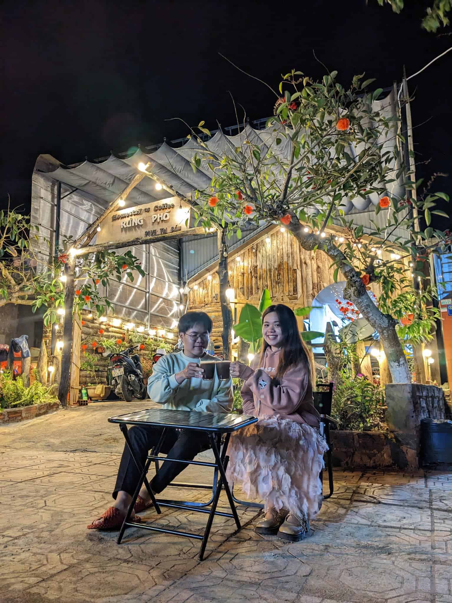 homestay Măng Đen khách ngồi uống cafe chụp ảnh trước cổng Rừng Phố homestay