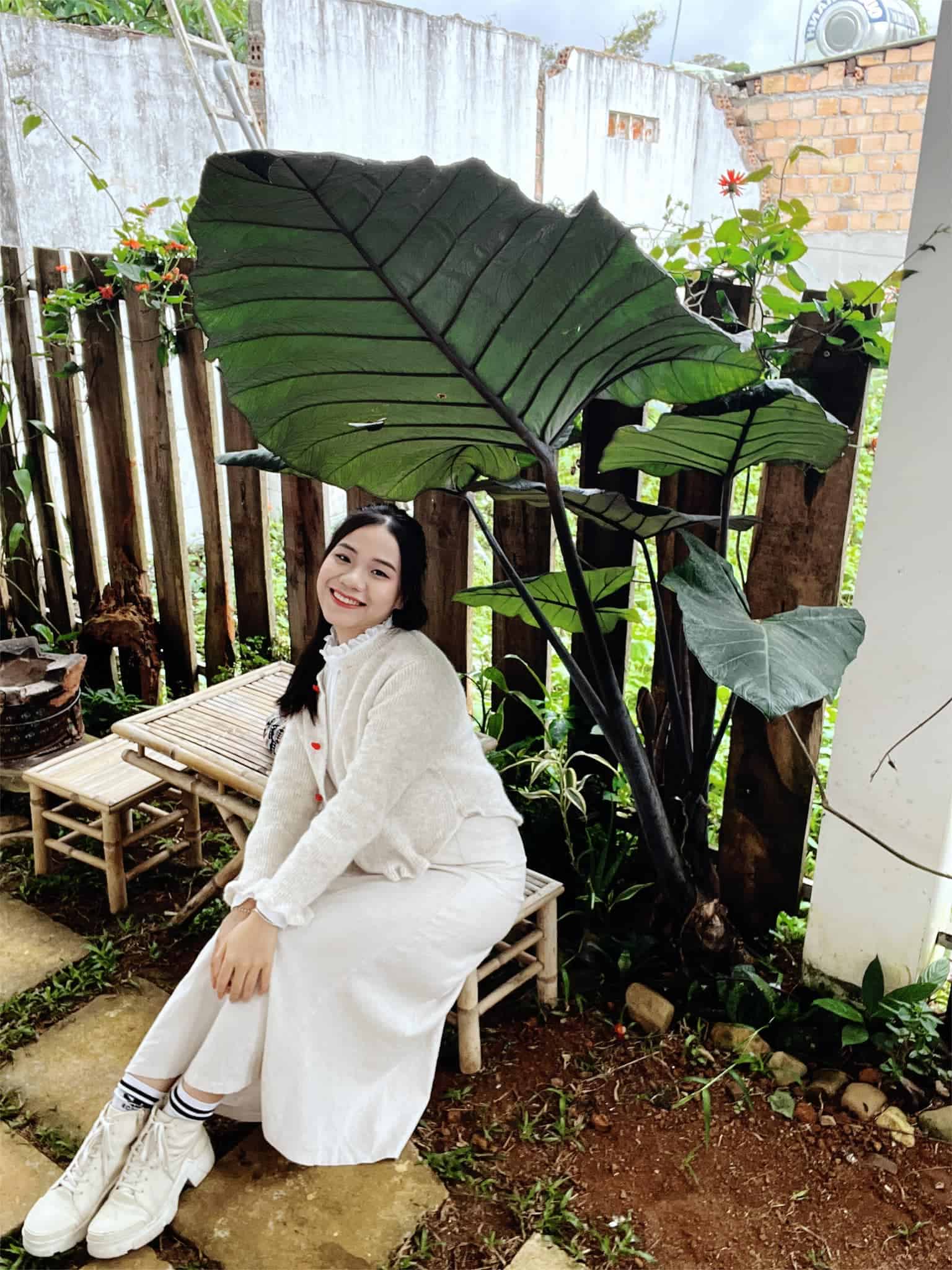 homestay mang den cố gái bên bộ bàn ghế tre ở Người Măng Đen Homestay