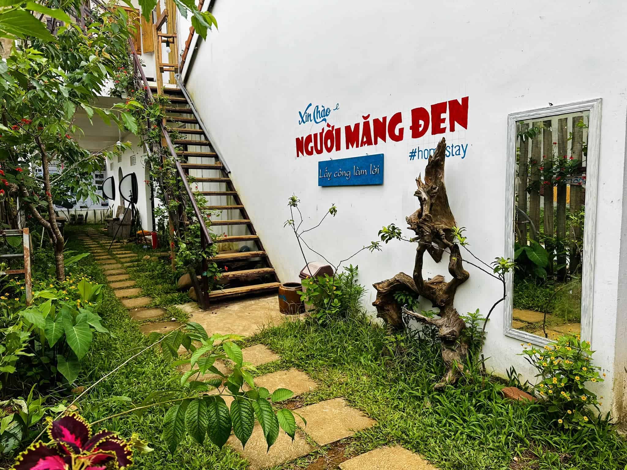 homestay mang den nhiều hoa, có bảng hiệu, cầu thang Người Măng Đen Homestay