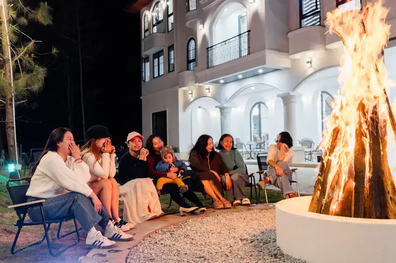 hotel mang den khách ngồi quay quần bên lửa trại trong khuôn viên
