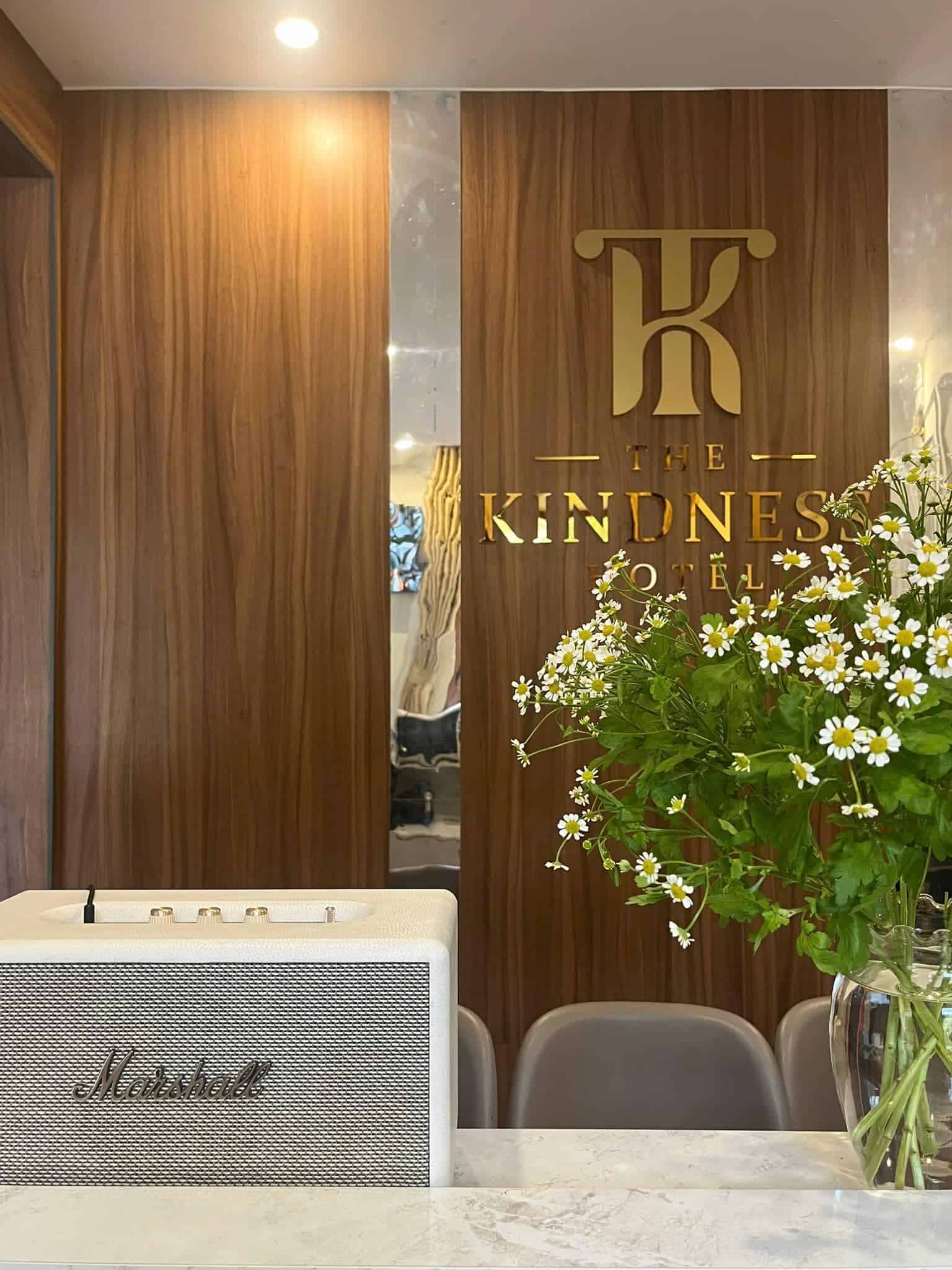 khach san mang den quầy lễ tân trang tri loa, hoa the kindness hotel