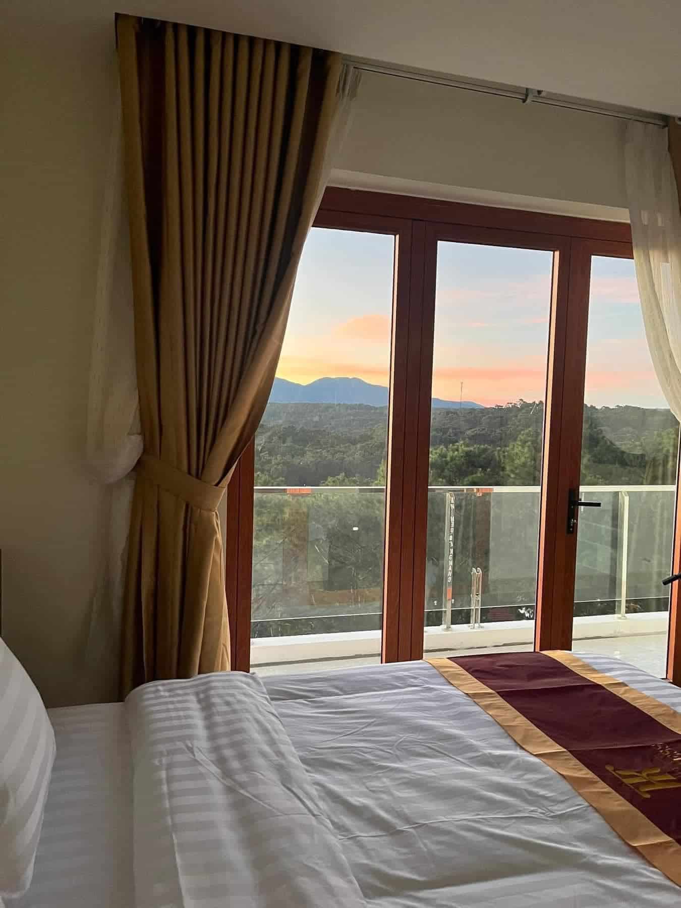 khach san mang den góc nhìn trong phòng qua cửa kính ra ban công ngắm núi rừng the kindness hotel