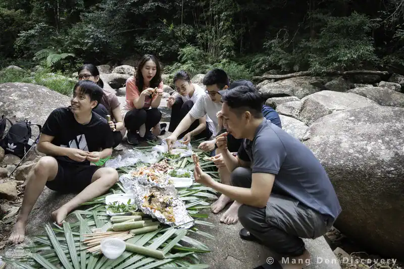 Trang Chủ 1 đoàn khách ngồi ăn bên bờ suối trong tour khám phá thác K50 Gia Lai