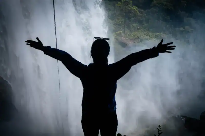 cô gái dang tay tận hưởng trong Hang Én tại thác K50 trong hành trình khám phá thác K50