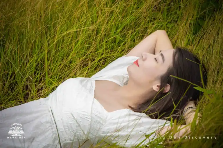 cô gái chụp ảnh cùng thảm cỏ khi nằm trên đó chill thật chill tại đồi cỏ 37 hộ Măng Đen trong chuyến lịch trình Măng Đen 3n2d