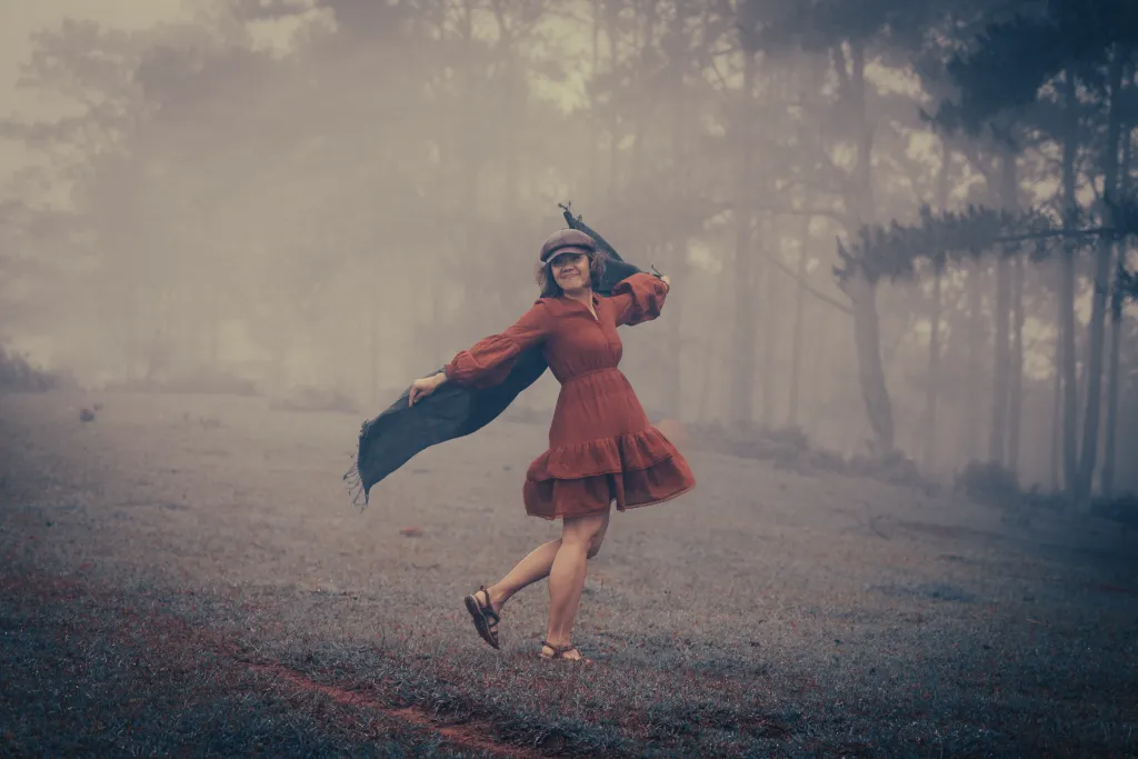 cô gái tạo dáng chụp ảnh vào sáng sớm còn rất nhiều sương phía sau là hàng thông rất đẹp tại đồi cỏ Kon Vơng Kia Măng Đen