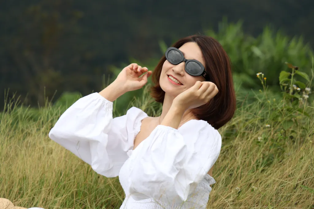 cô gái mang kính đen cùng áo trắng tại đồi cỏ 37 hộ Măng Đen vào buổi sáng sớm trong một chuyến tham quan tại Măng Đen