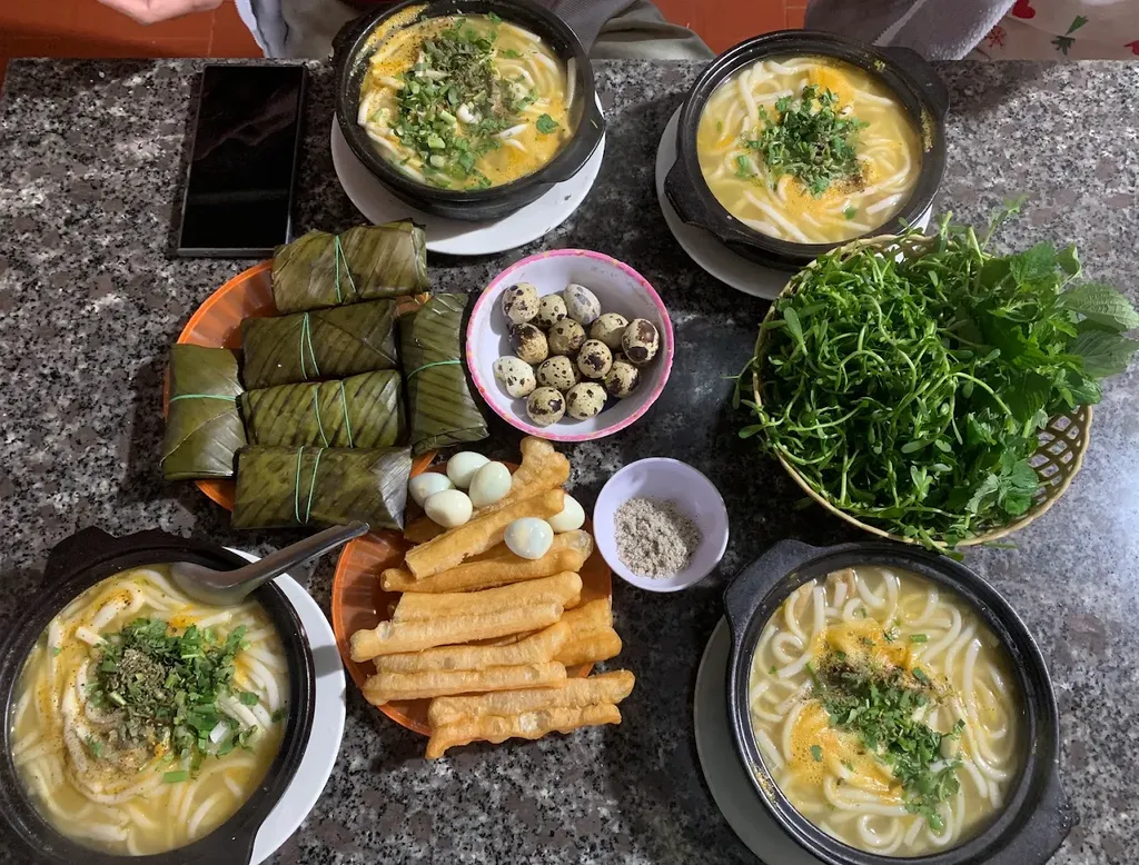 bàn ăn với nhiều tô bánh canh cá lóc A Kay 7 Măng Đen và rau ăn kèm