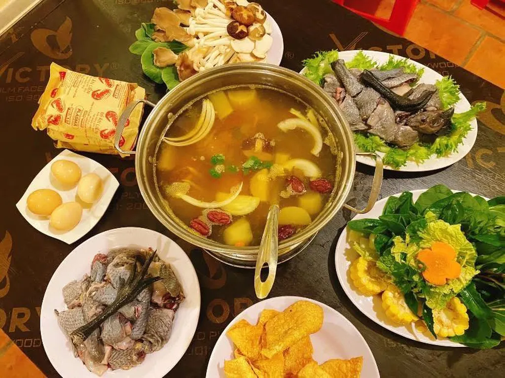 Nồi lẩu nấm tại Nấm Nhà Lành Măng Đen đặt giữa bàn cùng rau, trứng và nhiều món ăn kèm