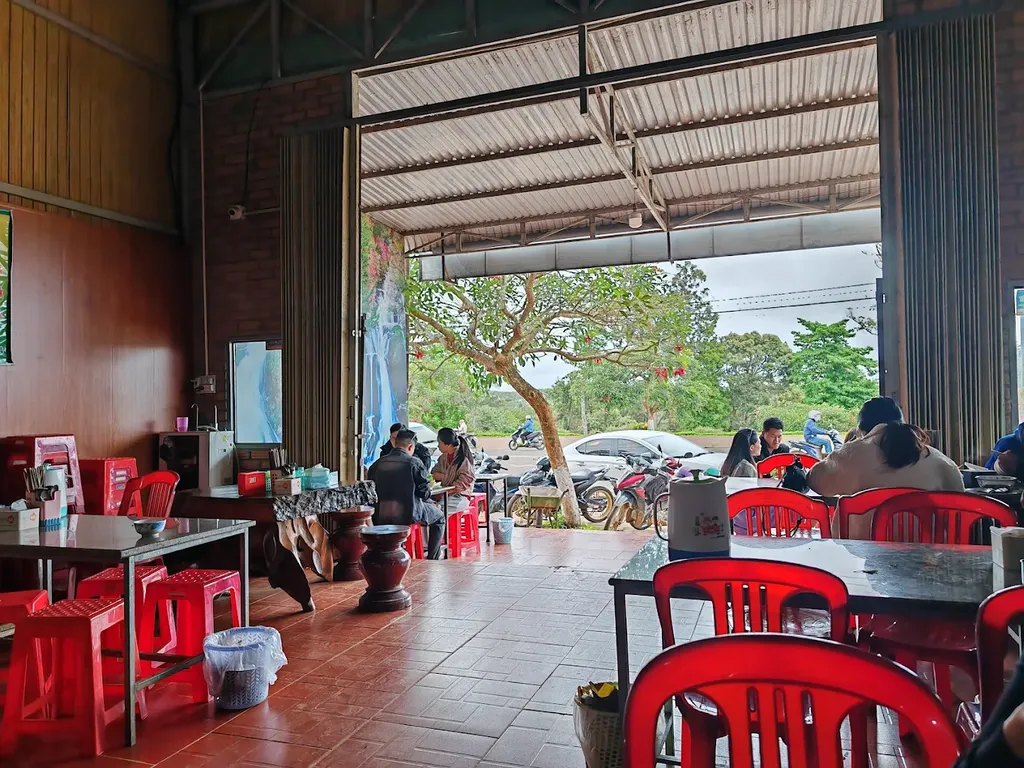 không gian ngồi ăn bên trong quán A Kay 7 Măng Đen với bàn ghế đỏ