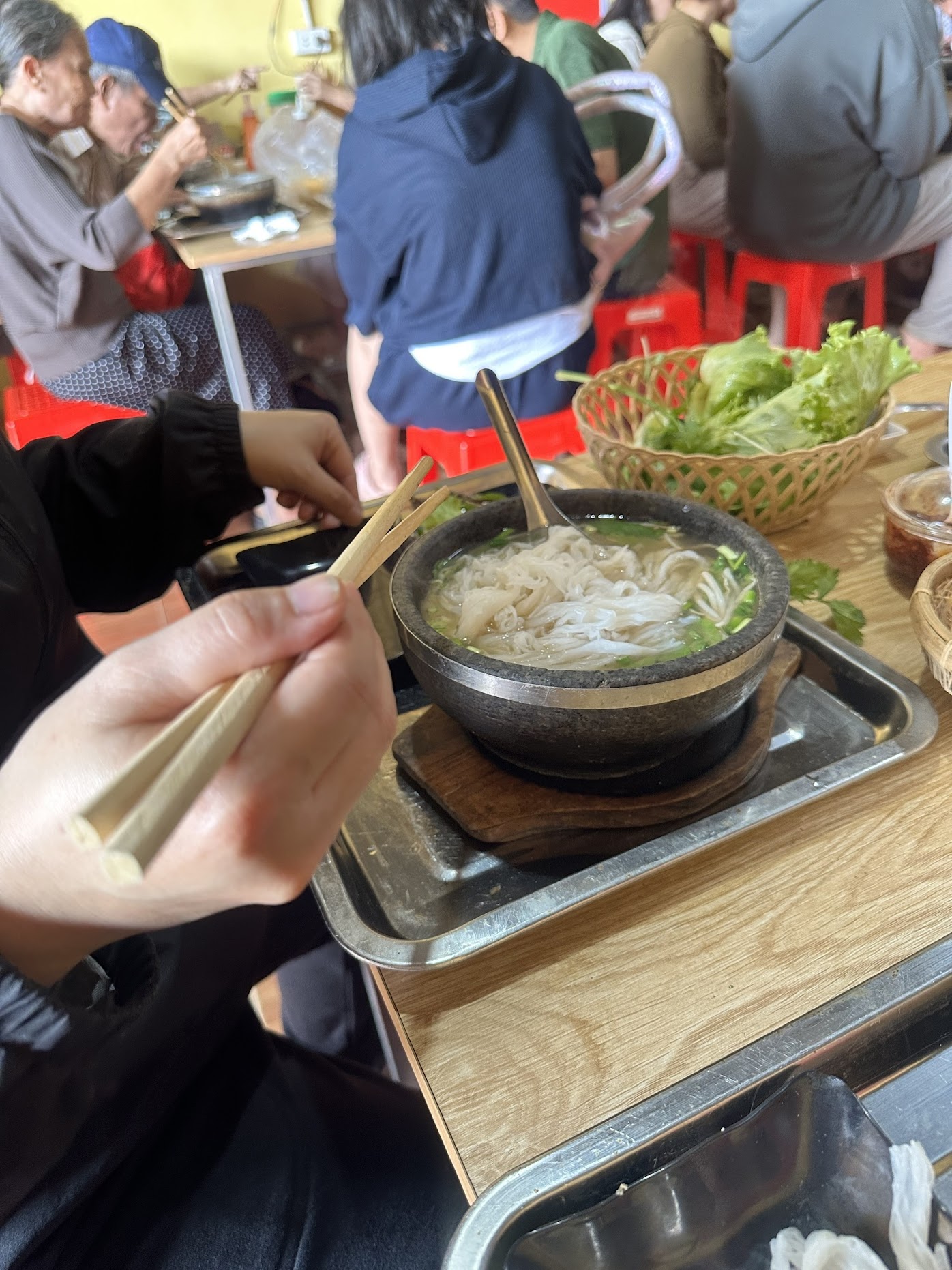 khách đang gắp bánh phở vào bát đá đang sôi