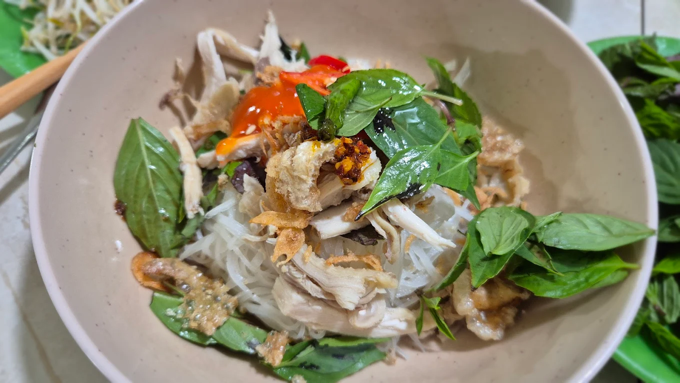 Cận cảnh tô phở khô gà tại Quán Bà Bảy Măng Đen với tóp mỡ giòn, rau thơm và ớt sốt
