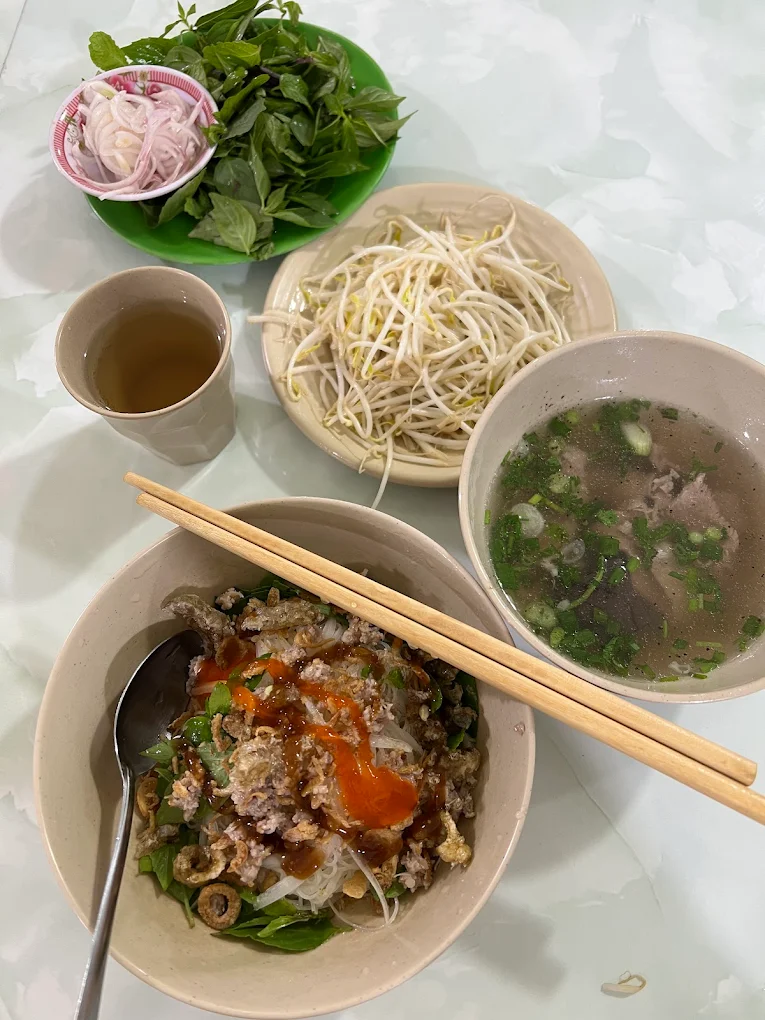 Một phần phở khô 2 tô tại Quán Bà Bảy Măng Đen gồm tô trộn, tô nước dùng, rau và giá đỗ