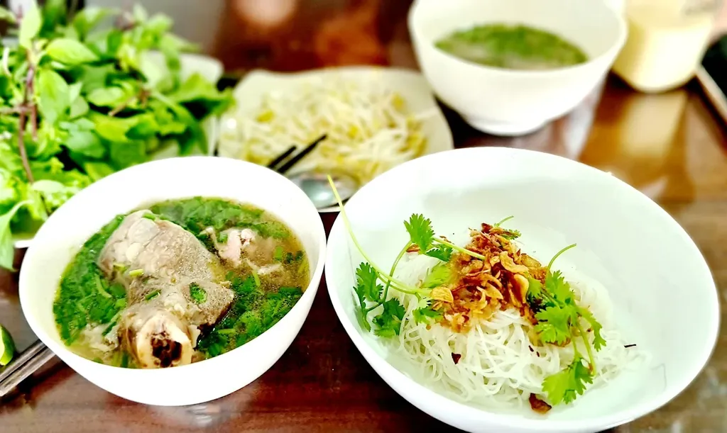 Hai tô phở khô và phở nước tại Phở Khô 79 Măng Đen trên bàn ăn buổi sáng