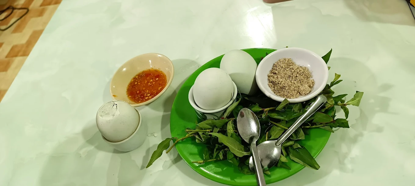 Đĩa trứng vịt lột, rau và chén muối tiêu tại Quán Bà Bảy Măng Đen